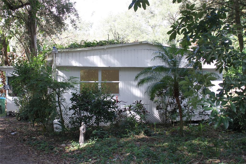 a backyard of a house with plants and lake view