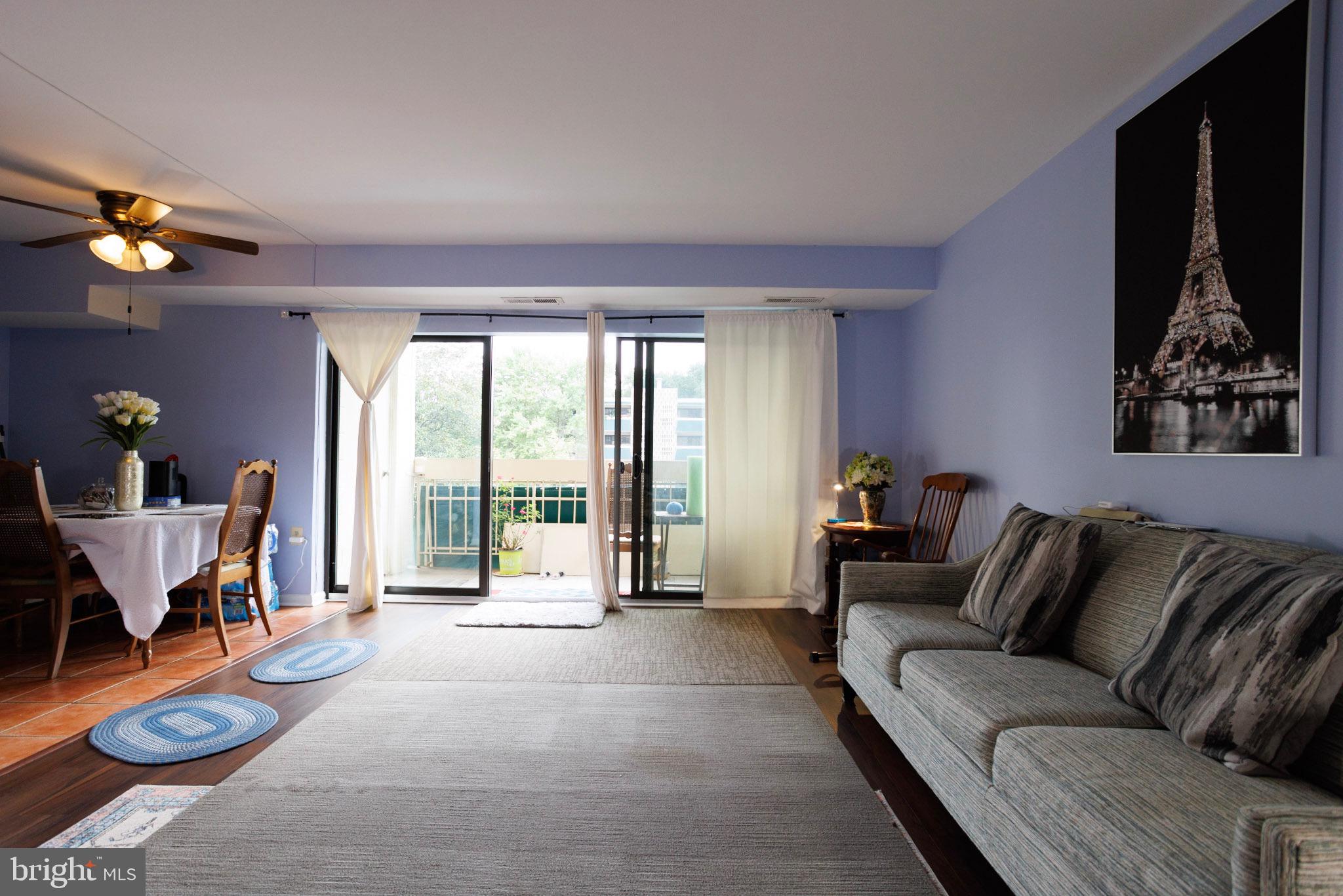 a living room with furniture a flat screen tv and a large window