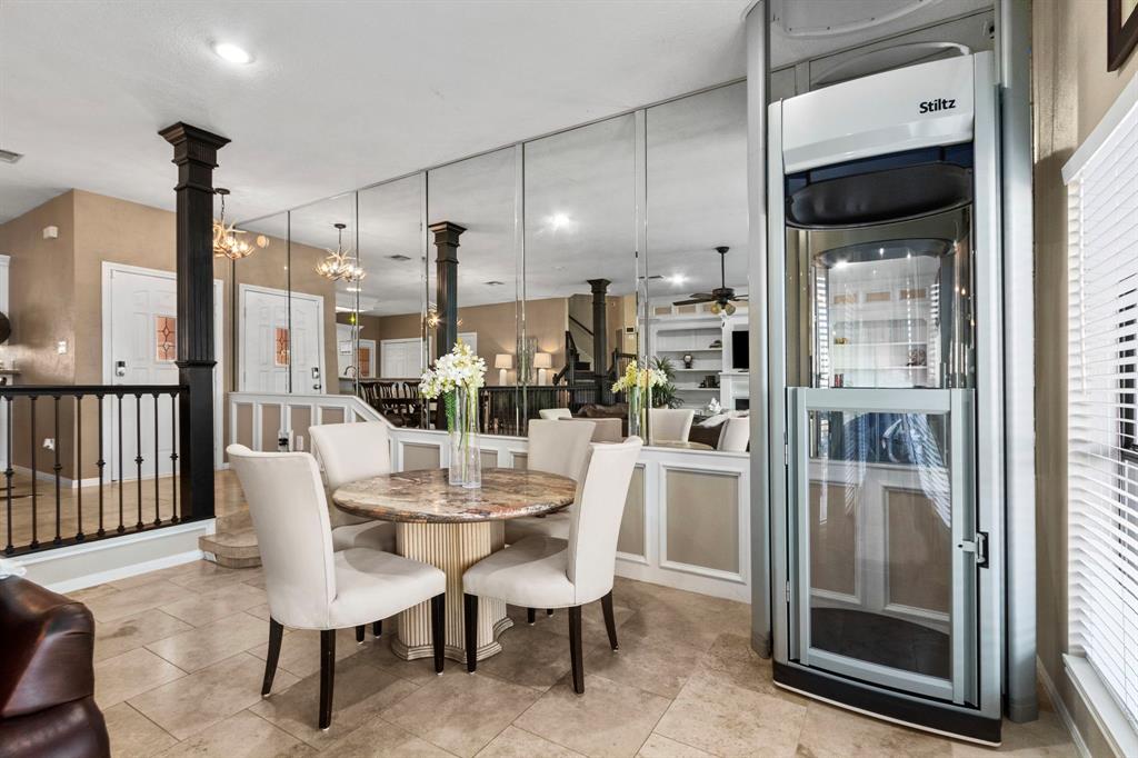 a dining room with stainless steel appliances furniture a large window and a kitchen view