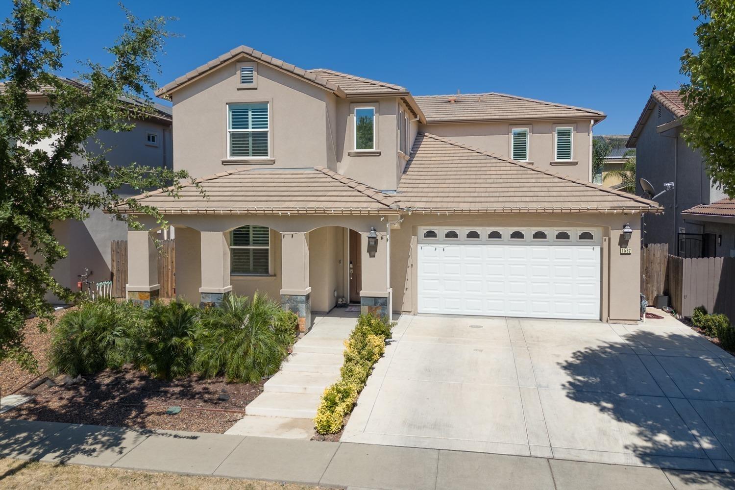 a front view of a house with a yard and garage