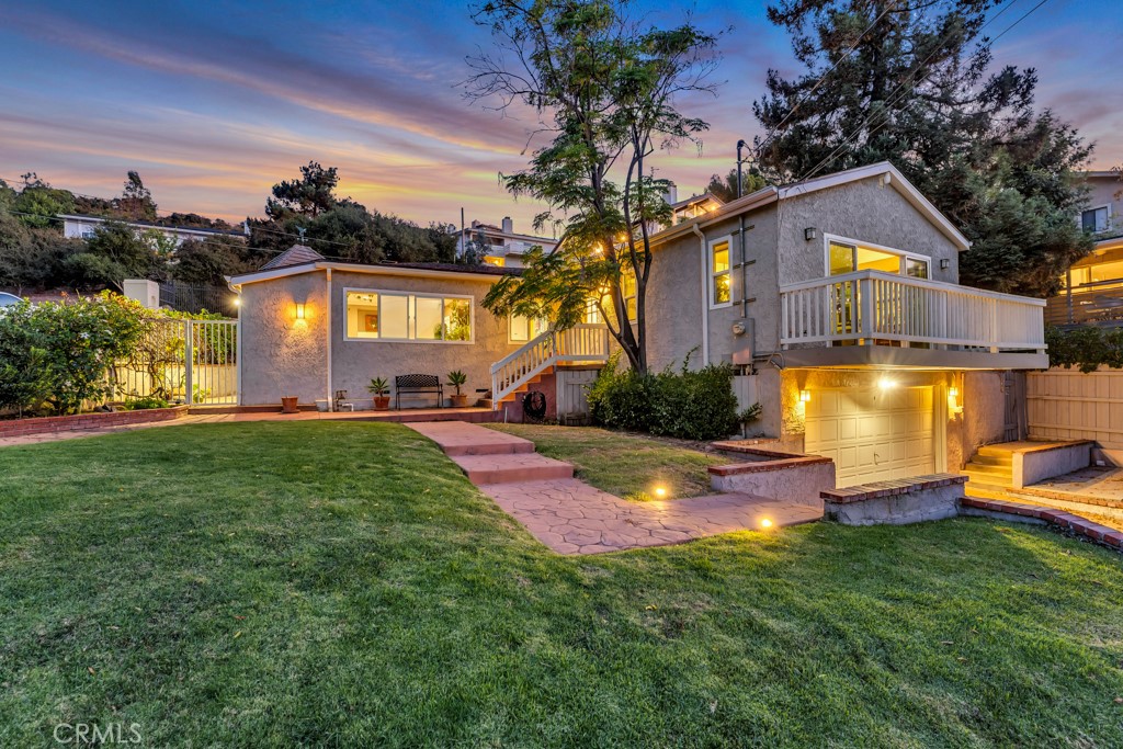 a view of a house with a big yard and a large tree