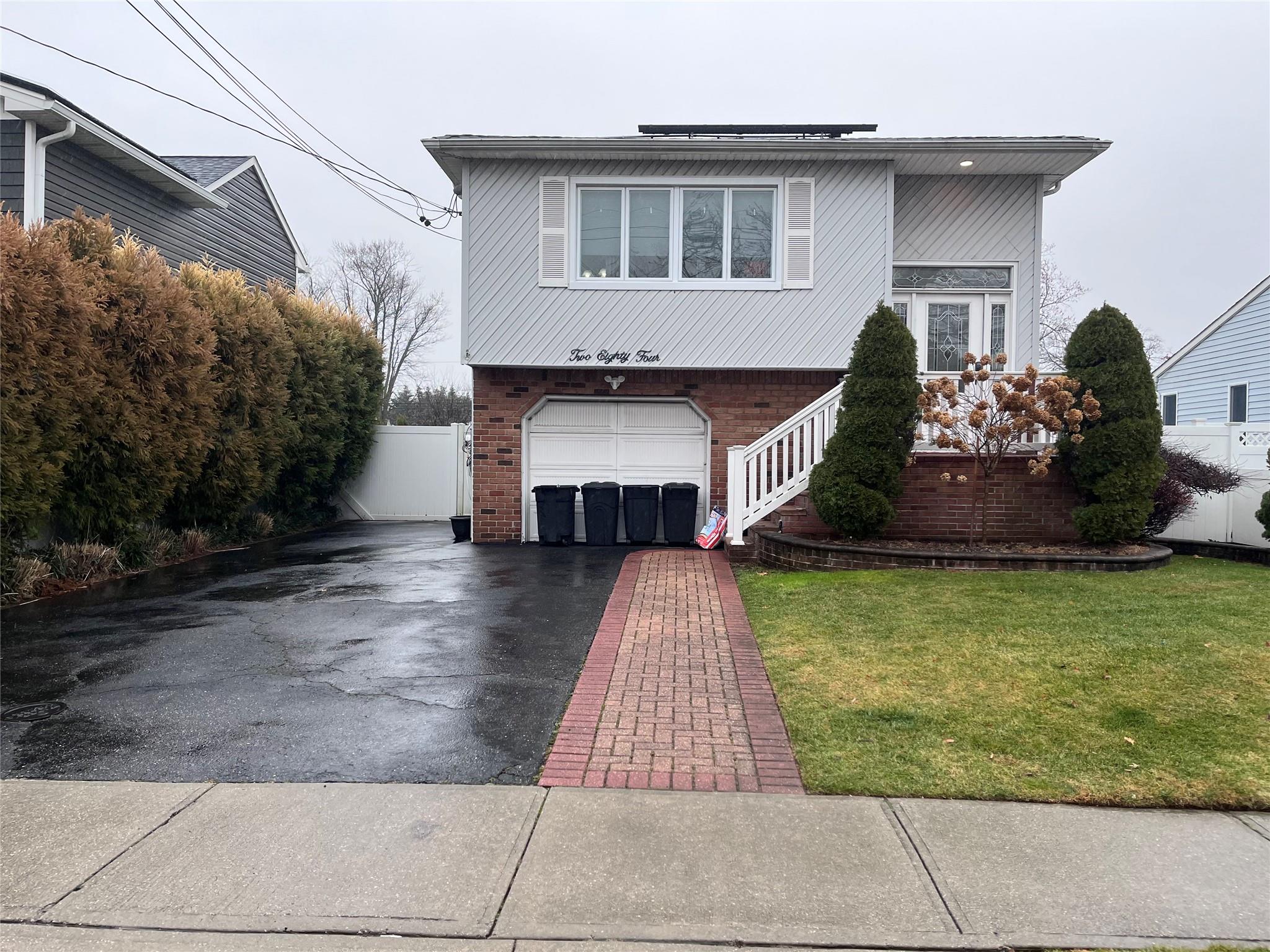 View of front of property with a front yard and a garage