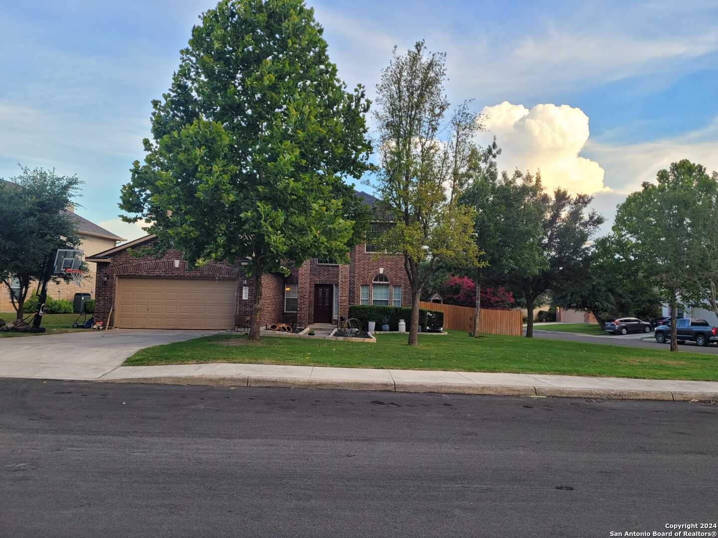 a view of a house with a yard and large trees