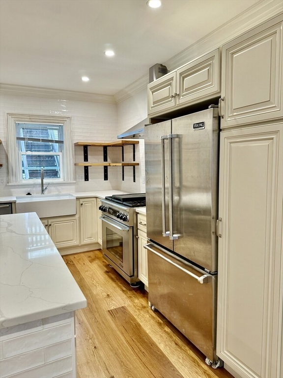 a kitchen with granite countertop a refrigerator stove and sink