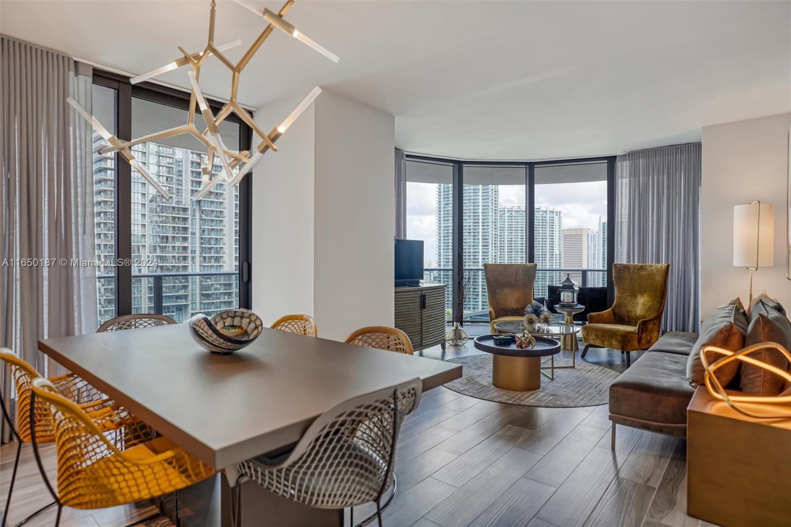 a living room with furniture a flat screen tv and a large window