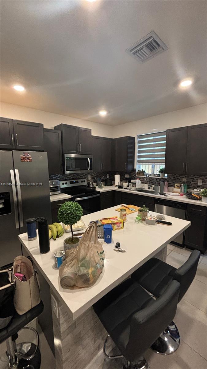 a kitchen with a sink a stove and chairs