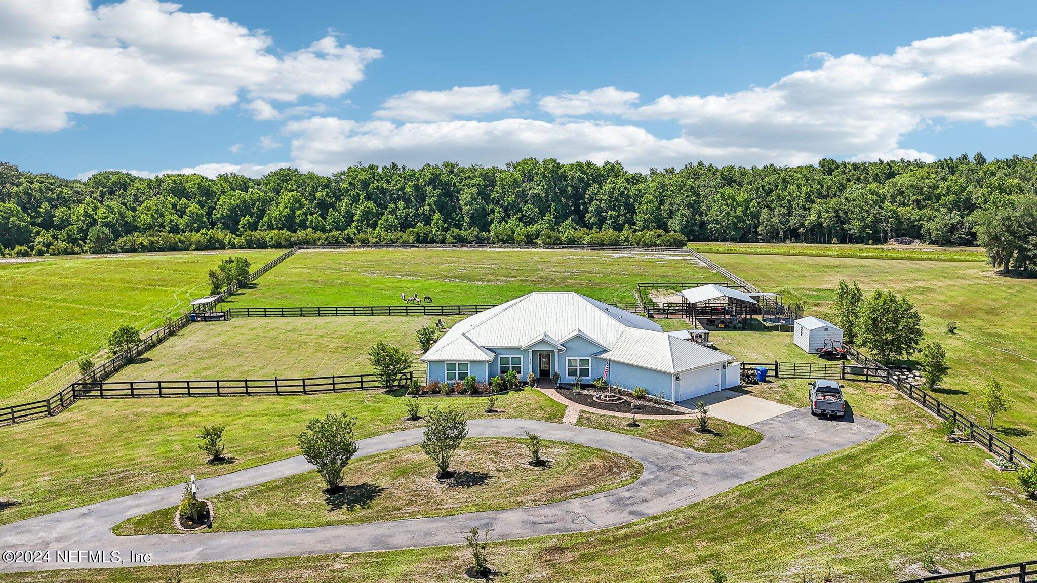 an aerial view of a house with swimming pool big yard and outdoor seating