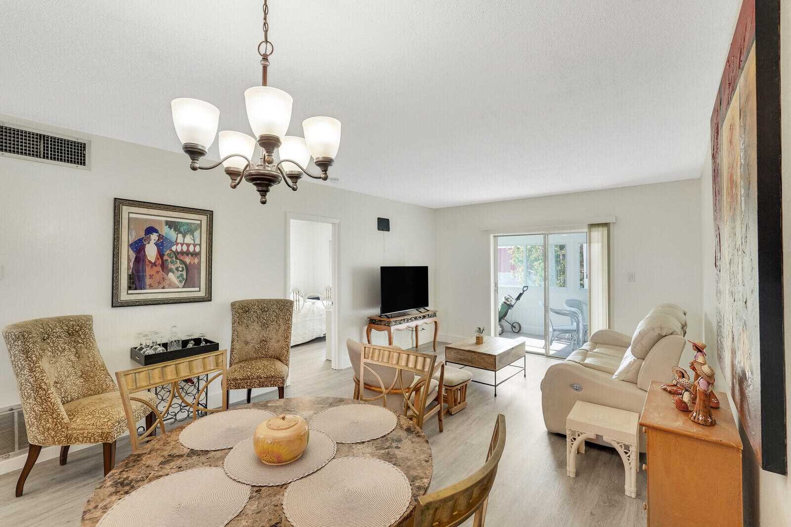 a living room with furniture chandelier and a flat screen tv