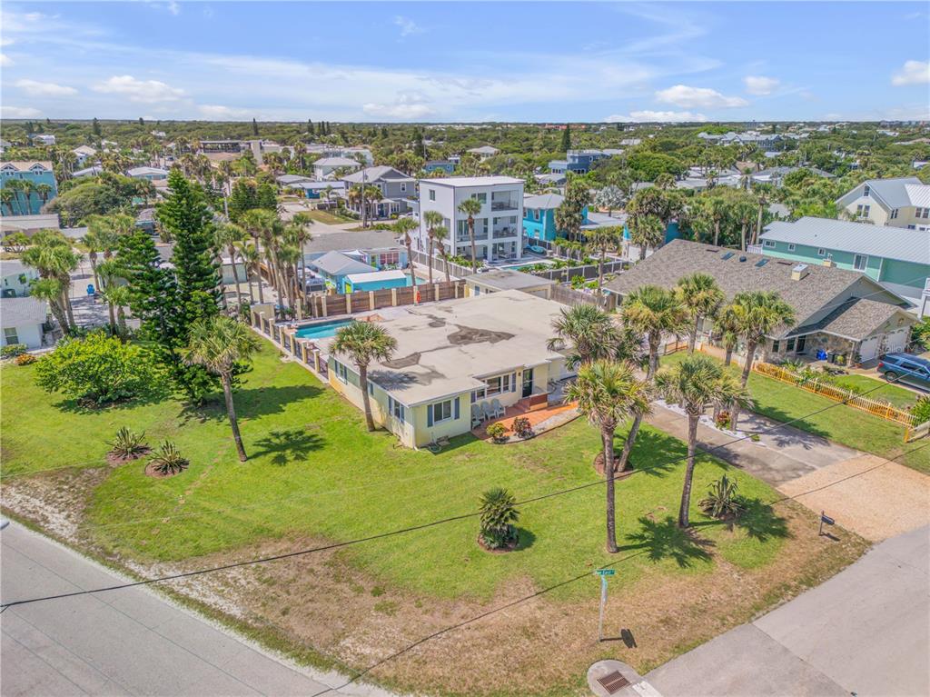 an aerial view of residential houses with outdoor space and trees