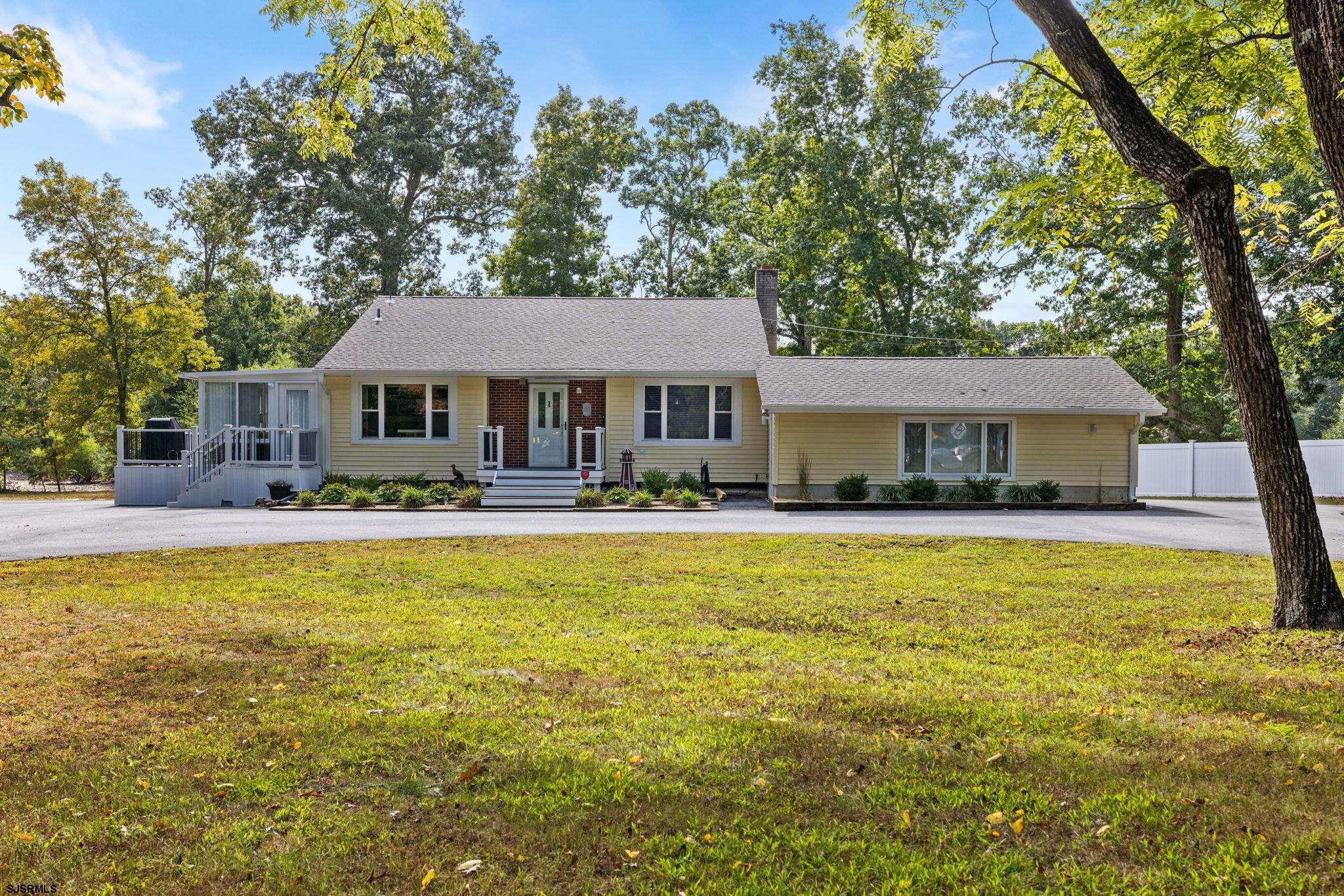 a front view of a house with swimming pool and porch with furniture