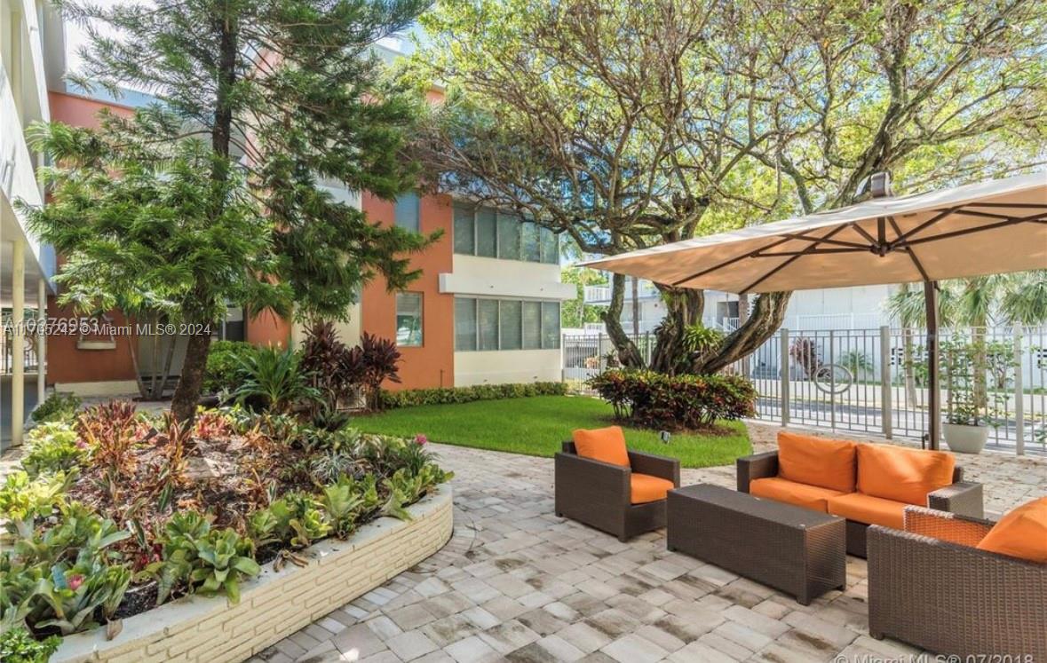 a view of a house with backyard and sitting area