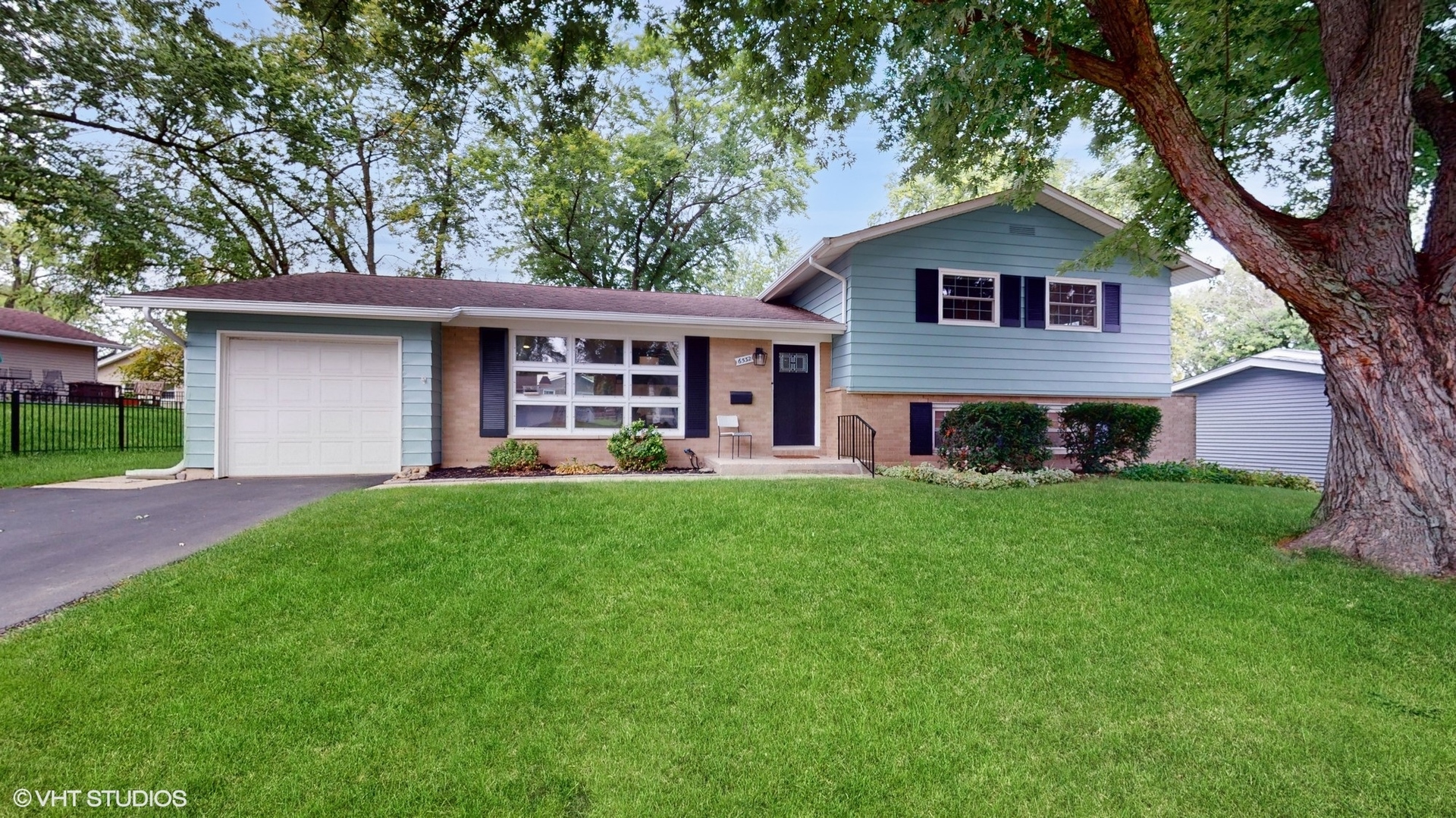 a front view of a house with a yard and green space