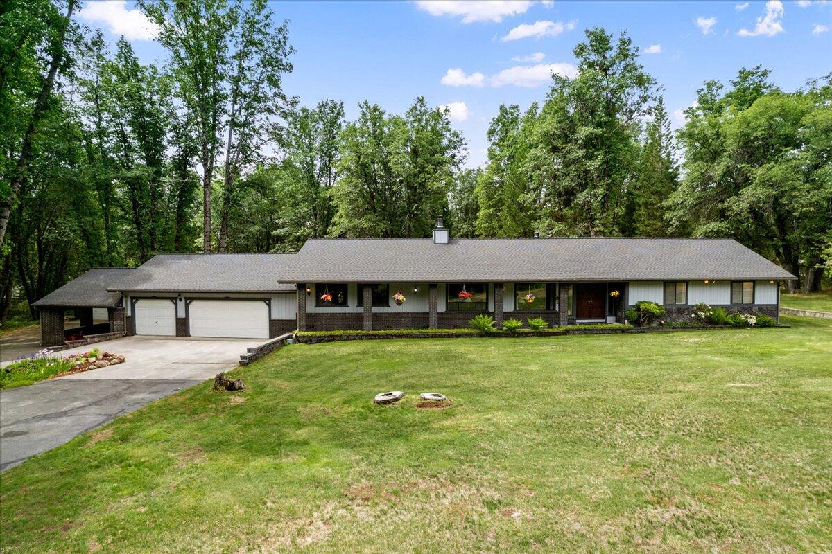 a aerial view of a house next to a big yard and large trees