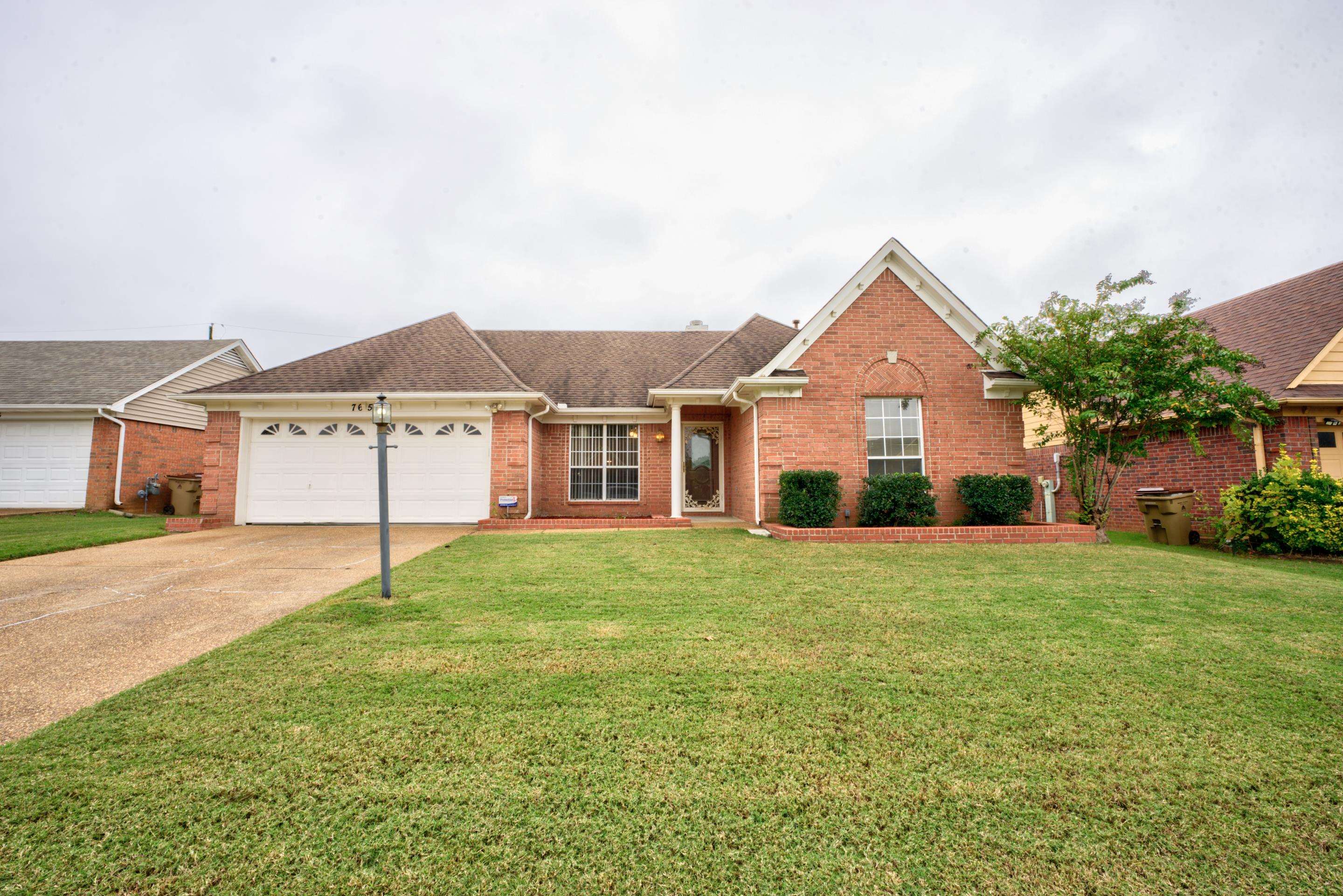 Ranch-style home with a garage and a front lawn