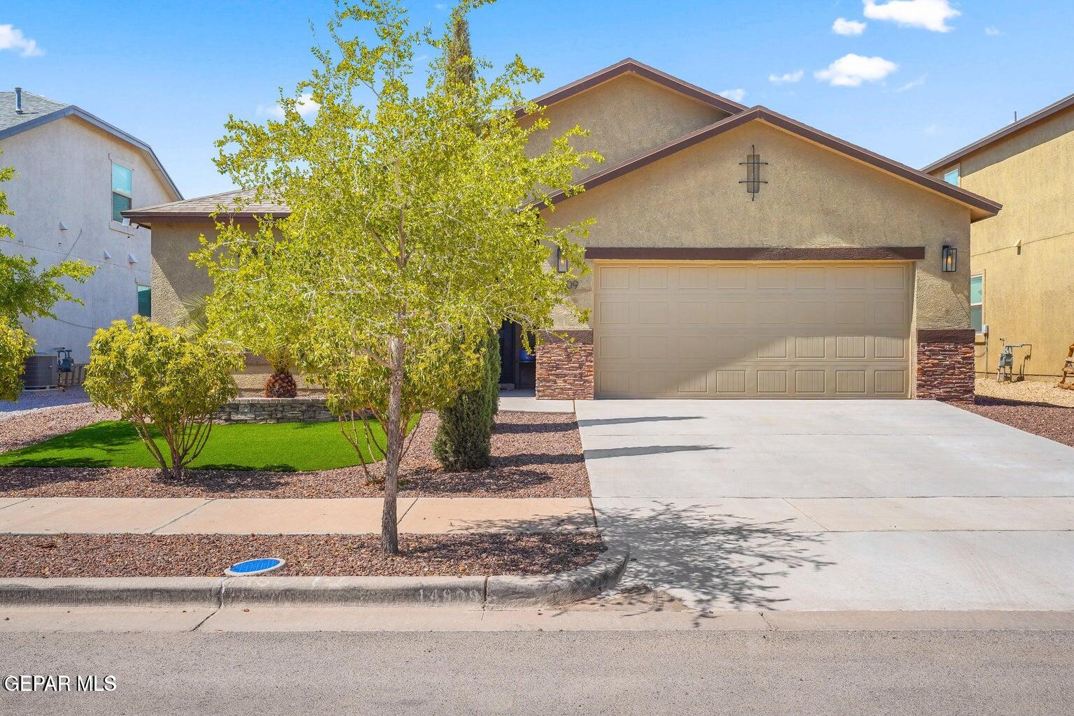 a front view of a house with a yard and garage