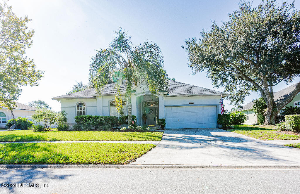 a front view of a house with a yard and garage