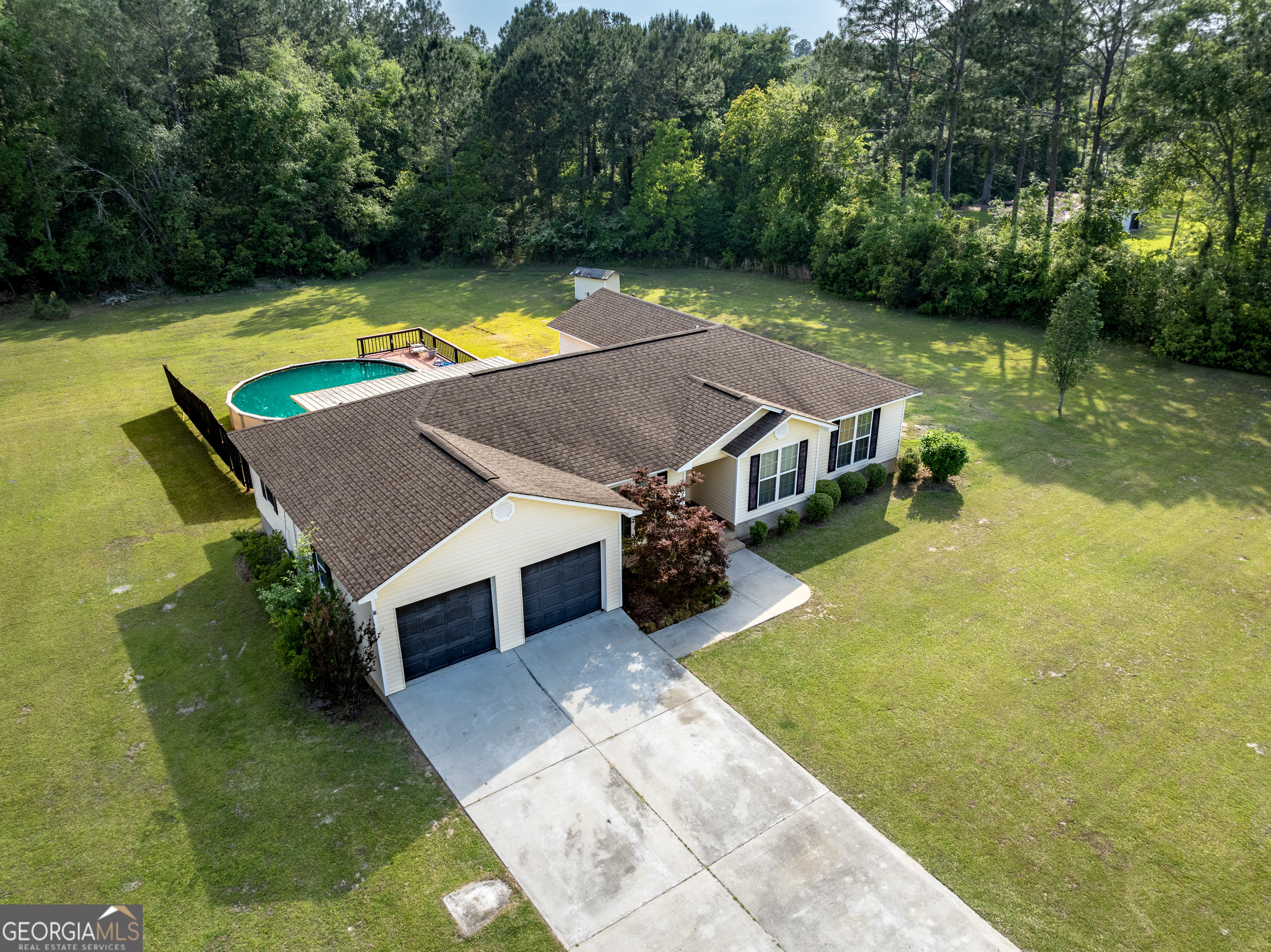 an aerial view of residential houses with yard and swimming pool