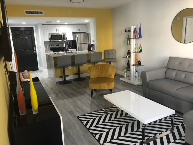 a living room with furniture and a view of kitchen