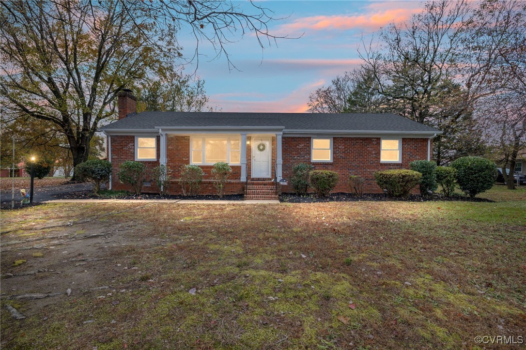 a front view of house with yard and trees around