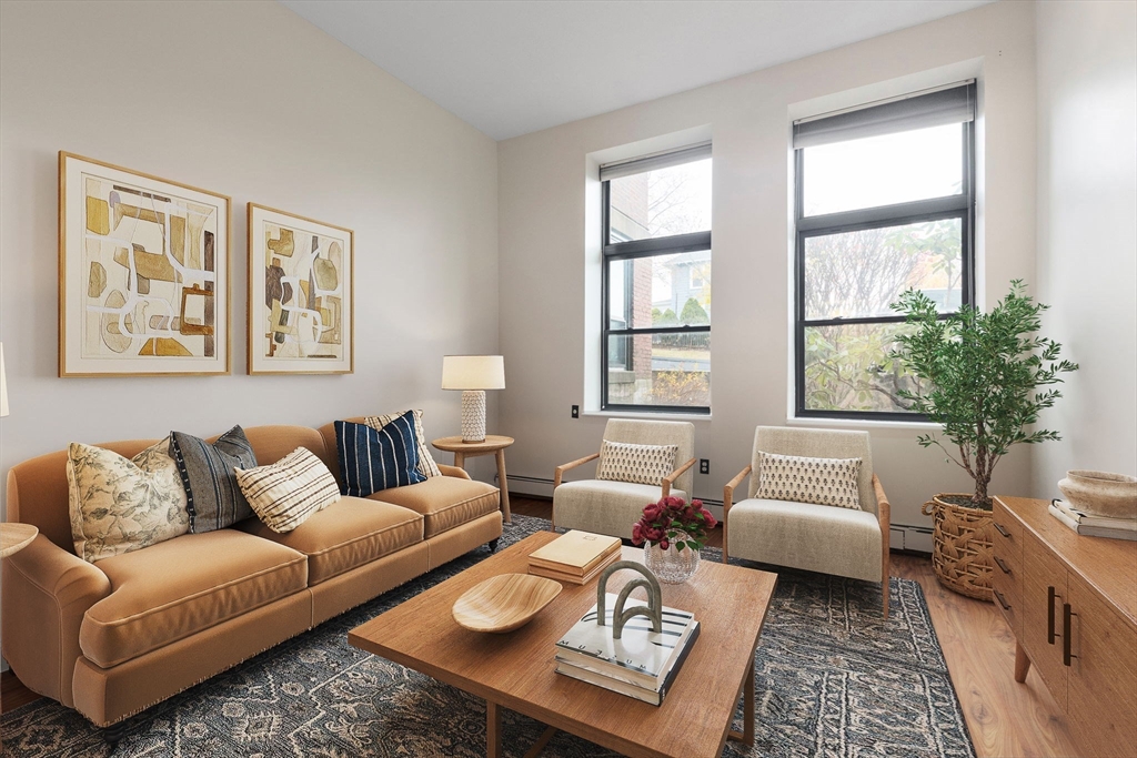 a living room with furniture a rug and a large window