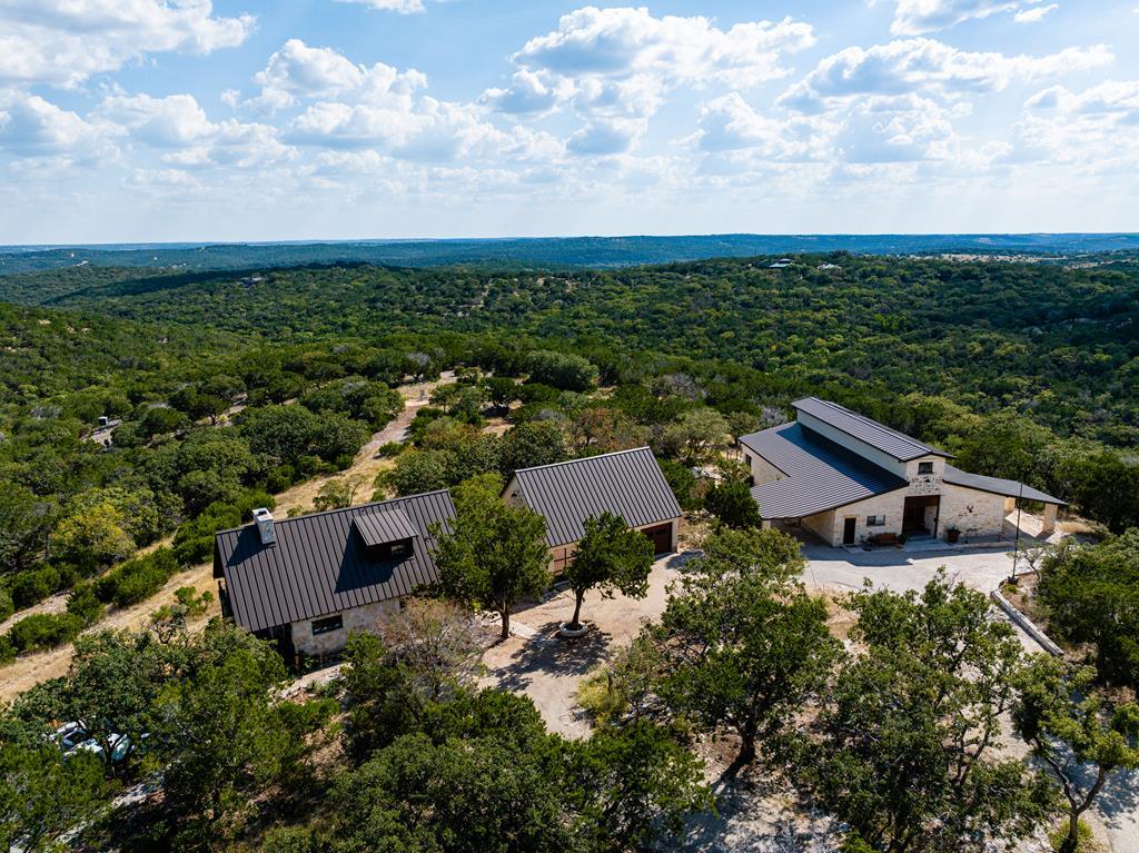 an aerial view of a house with garden space and lake view in back