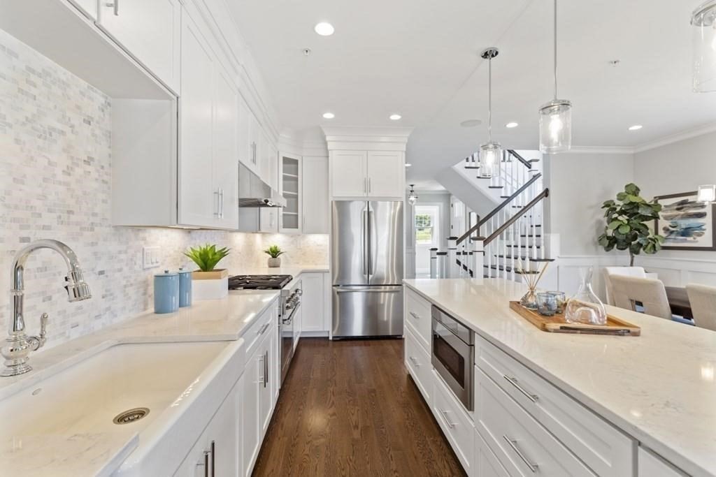 a open kitchen with stainless steel appliances granite countertop a sink a stove and a wooden floors