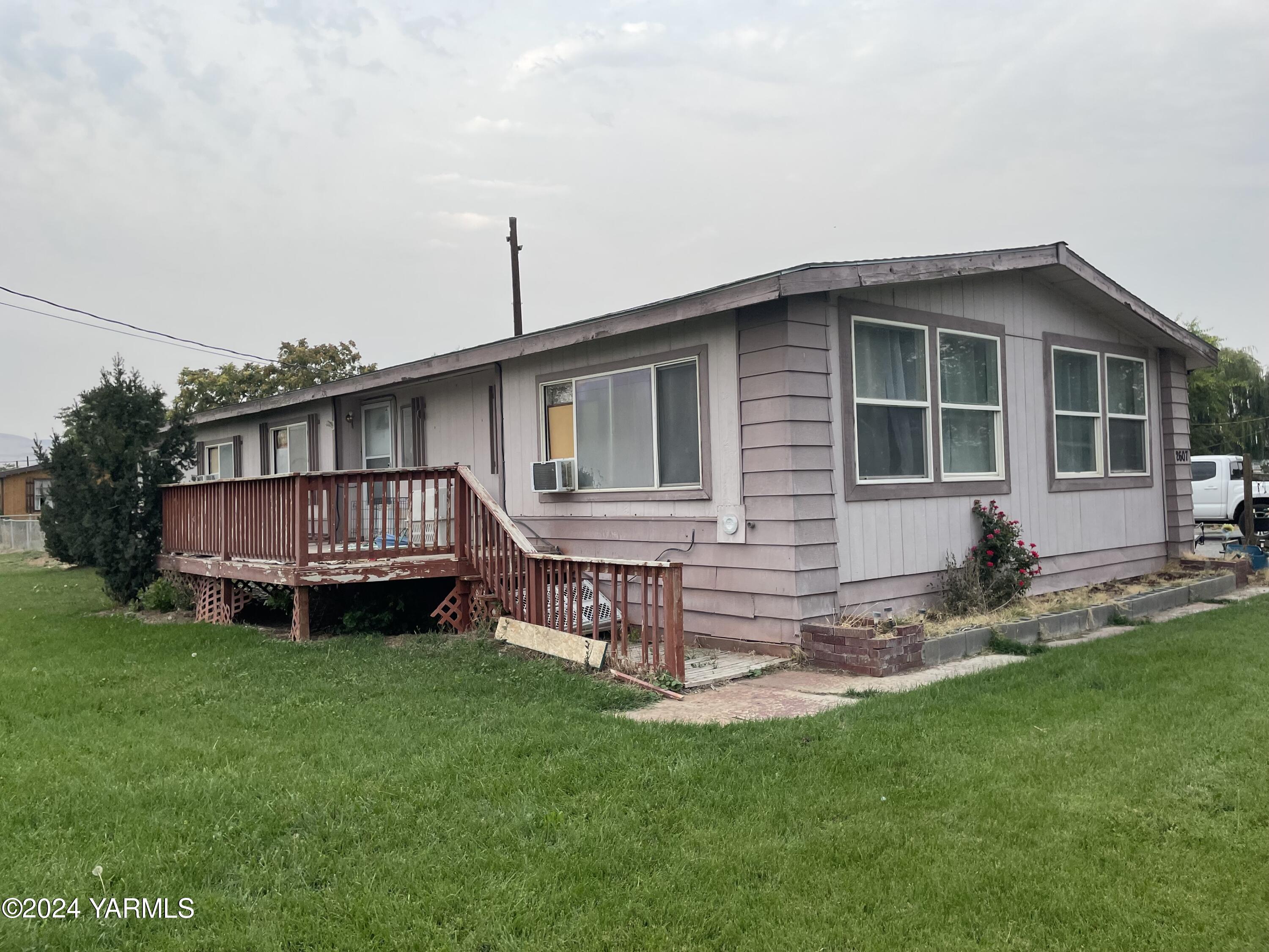 a view of a house with a yard and deck