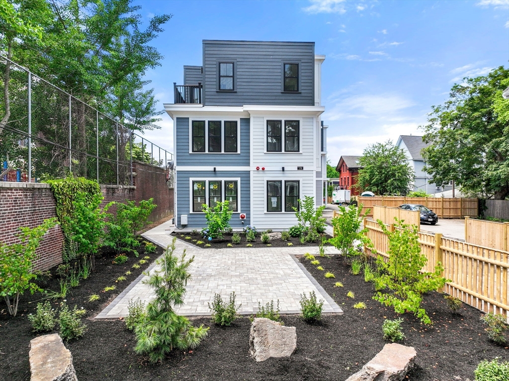 a view of a house with backyard and sitting area