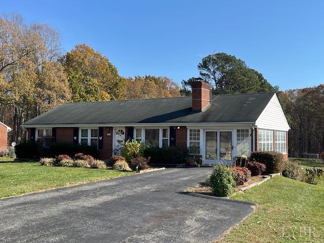 a front view of house with yard and trees in the background