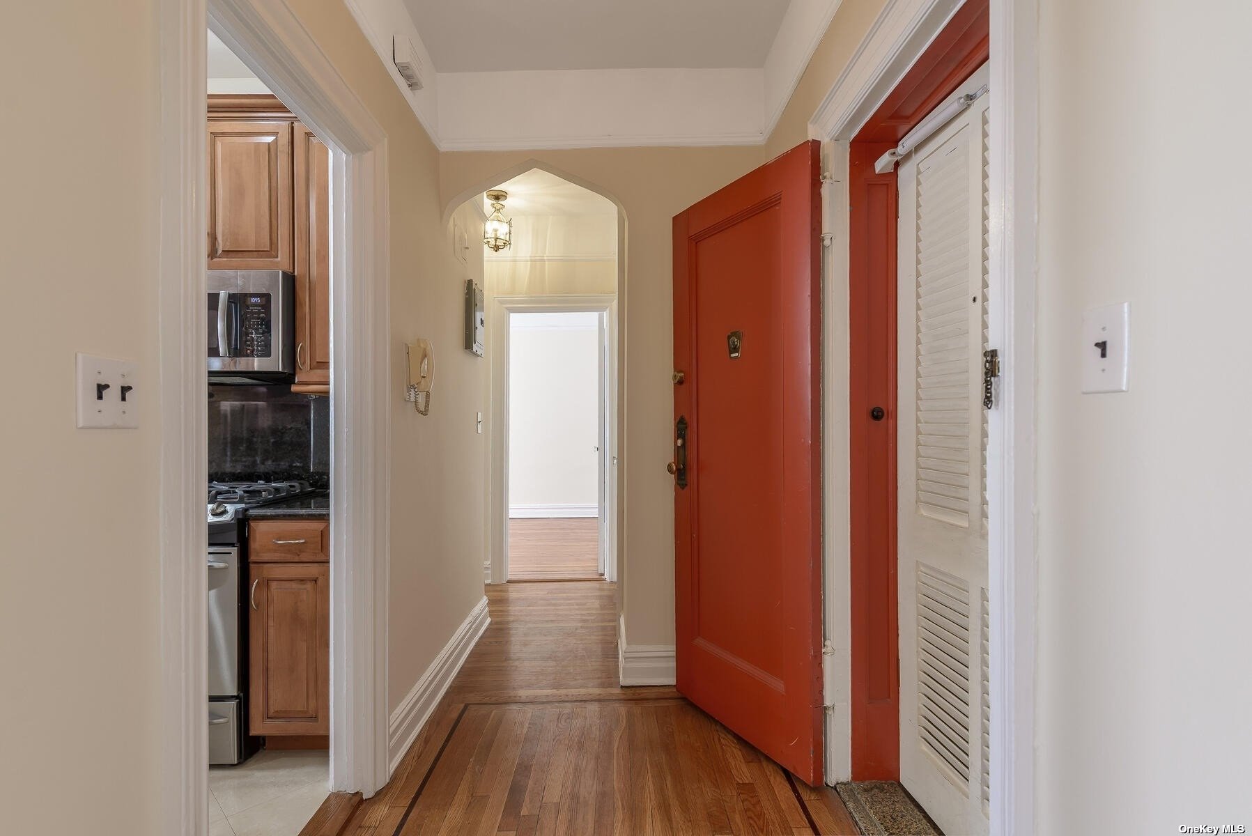 a view of a hallway with wooden floor and entryway