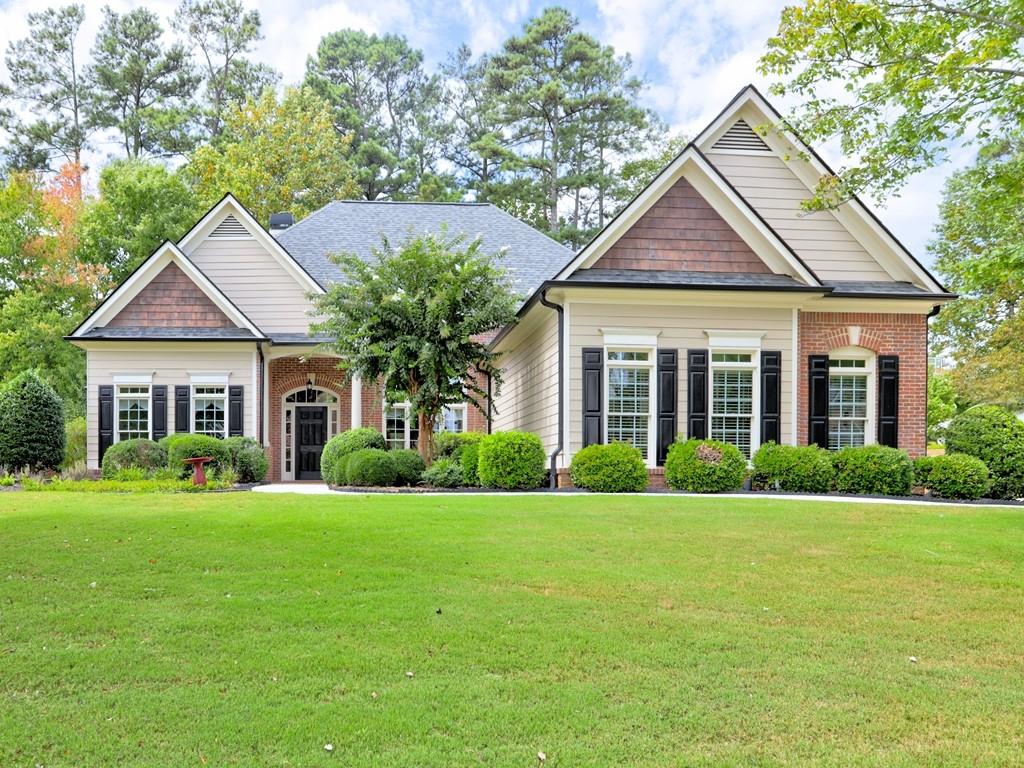 a front view of a house with a yard and trees