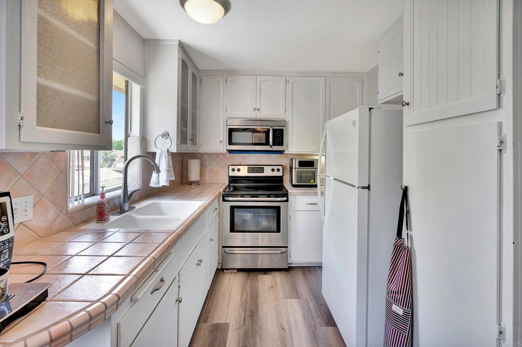 a kitchen with granite countertop a refrigerator stove and sink