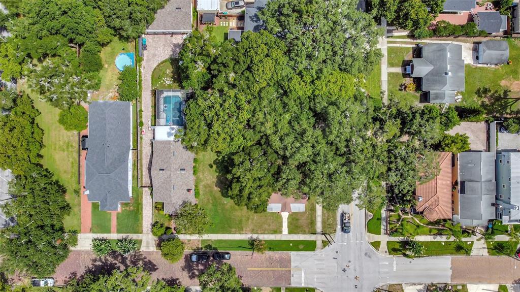 an aerial view of a residential apartment building with a yard and large trees