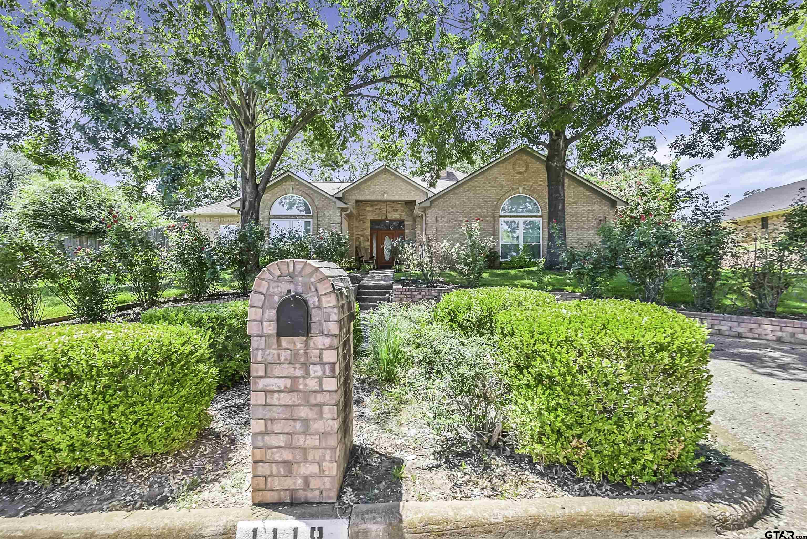 a front view of a house with a yard and potted plants