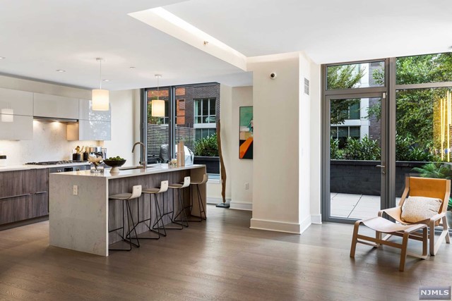 a view of a kitchen with stainless steel appliances wooden floor and a large window