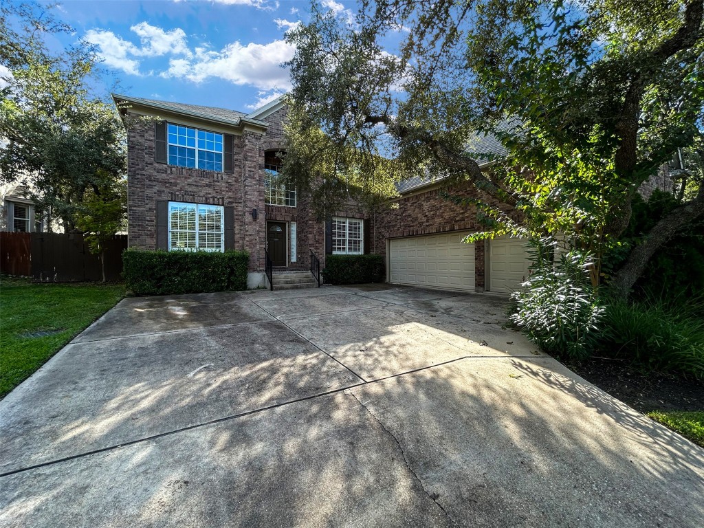 a front view of a house with a garden and trees