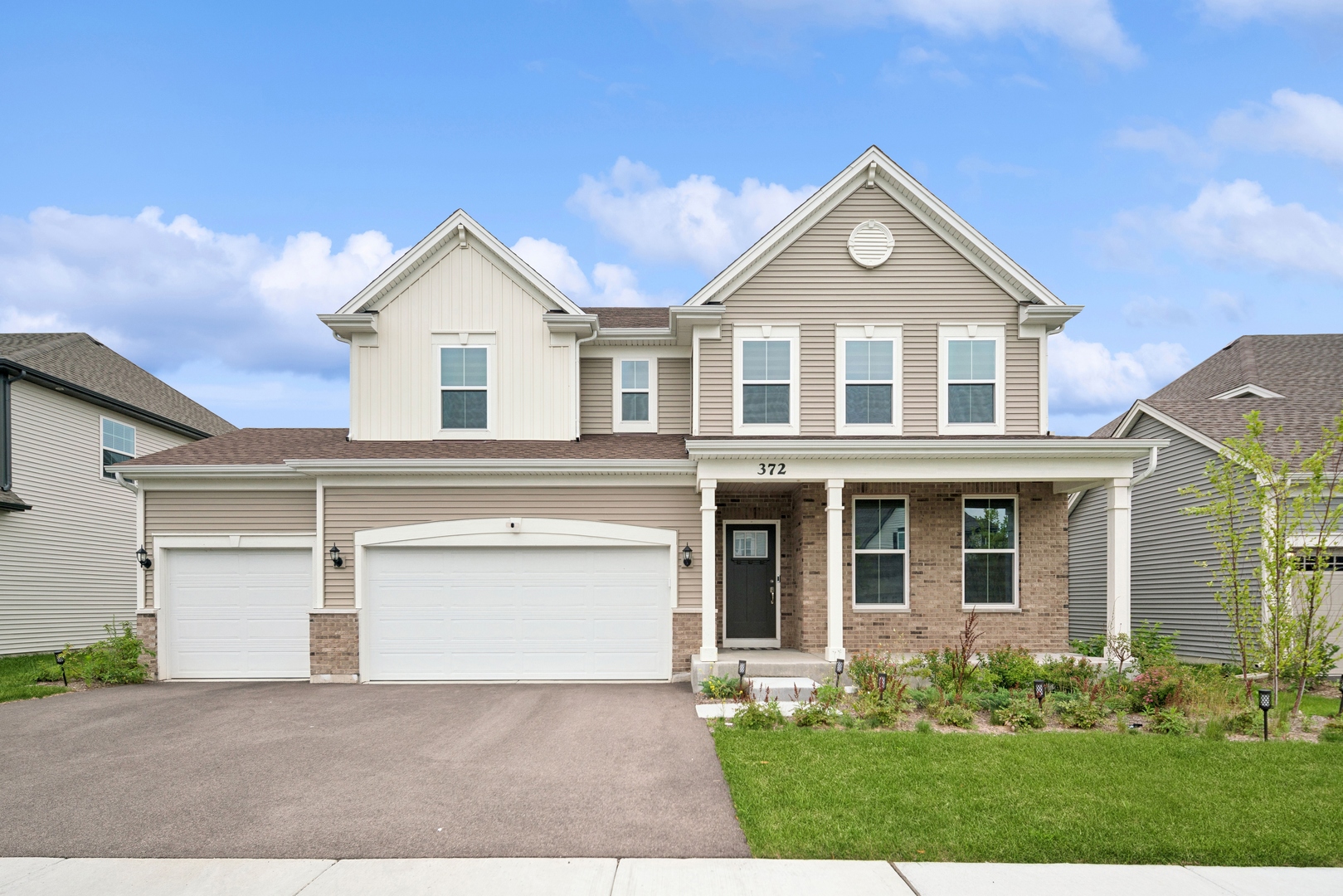 a front view of a house with a yard and garage