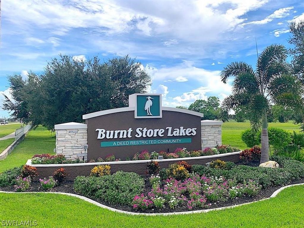 a view of a sign in front of a house with a garden