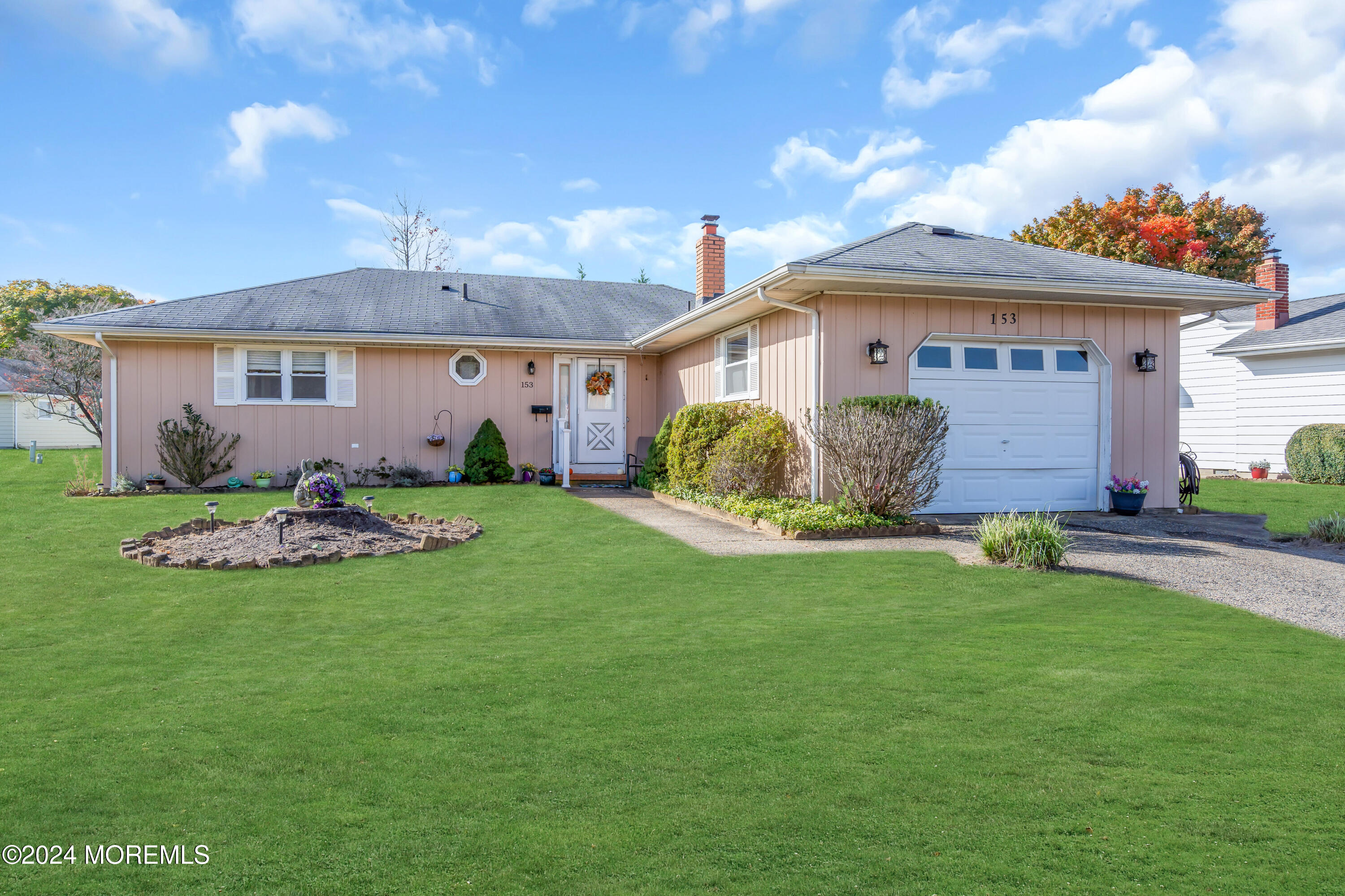 a front view of a house with a garden and plants