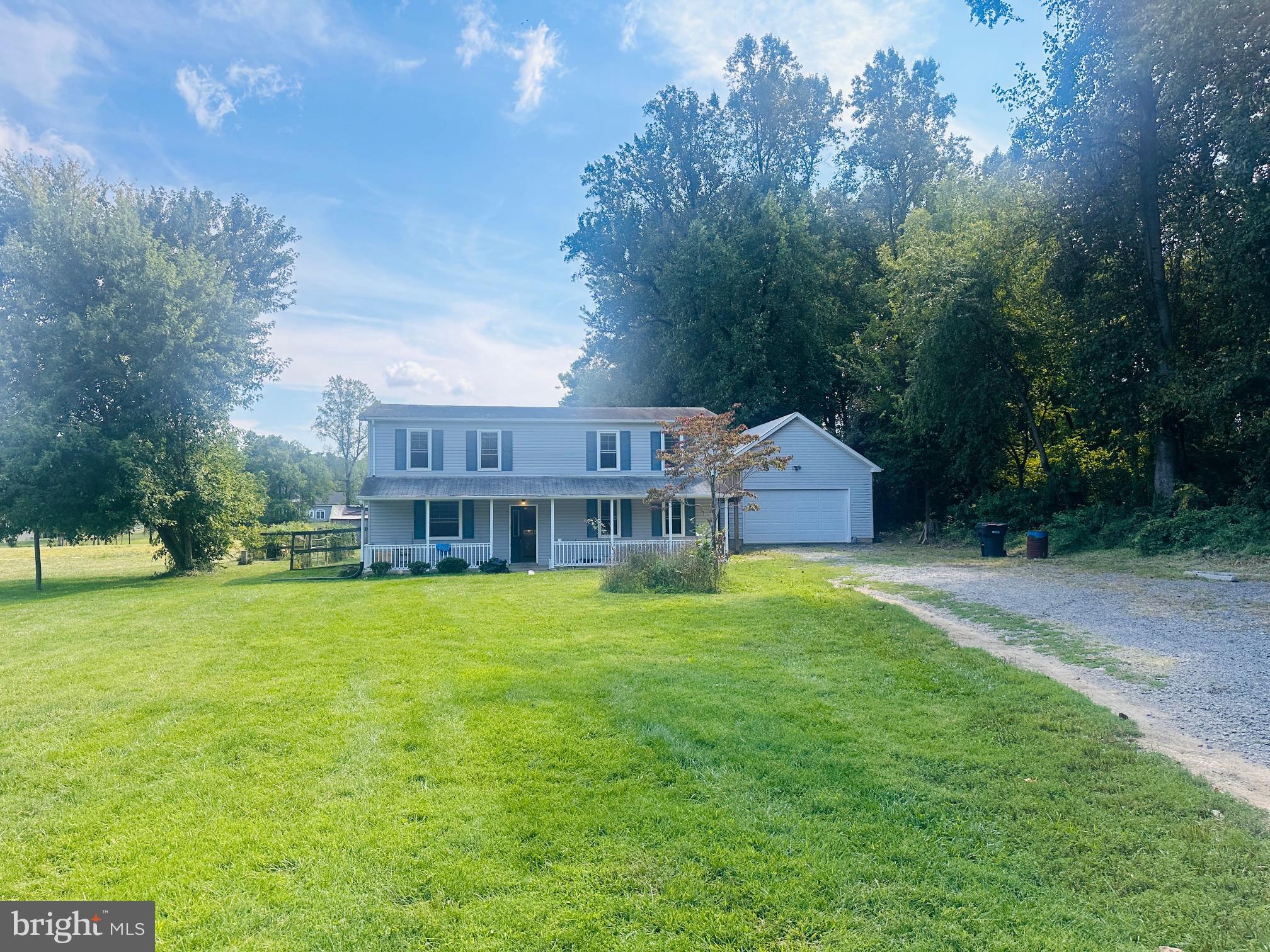 a view of a big house with a big yard and large trees