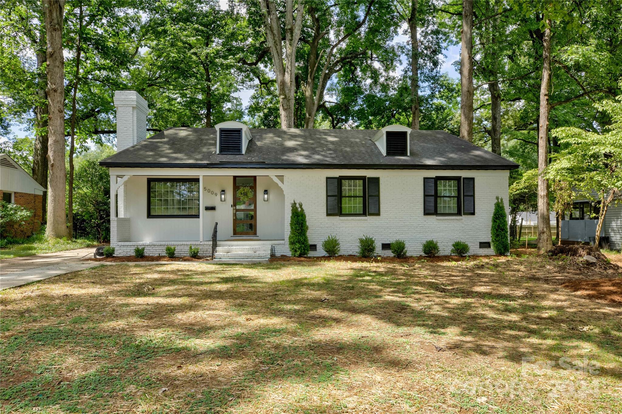 a front view of a house with a garden