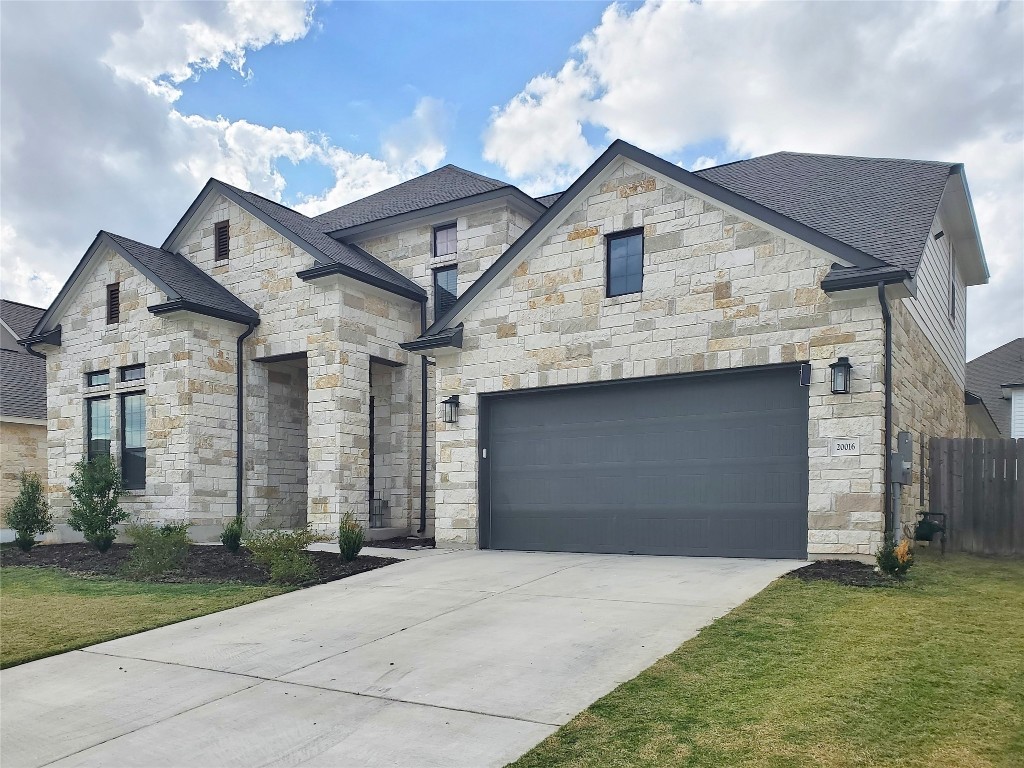 a front view of a house with a yard and garage