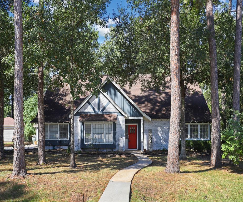 a front view of a house with a yard covered in snow and trees