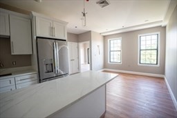 a view of a kitchen with a sink and a refrigerator