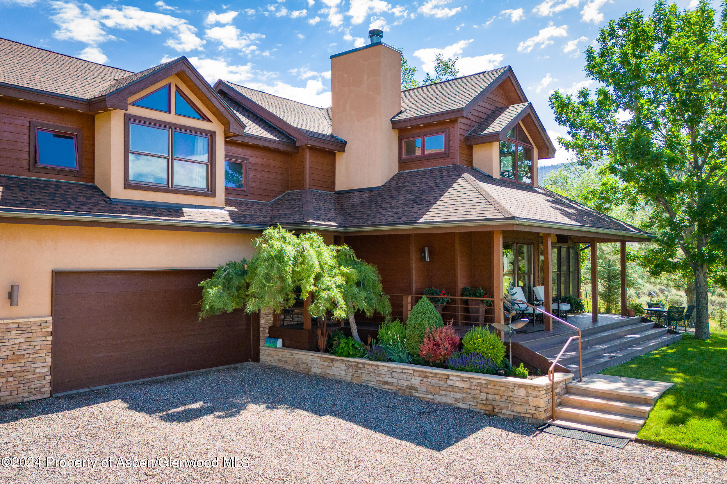 a front view of a house with a yard and potted plants