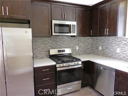 a kitchen with stainless steel appliances wooden cabinets and a stove