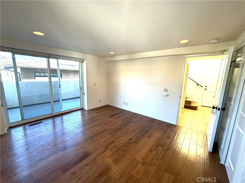 an empty room with wooden floor and door