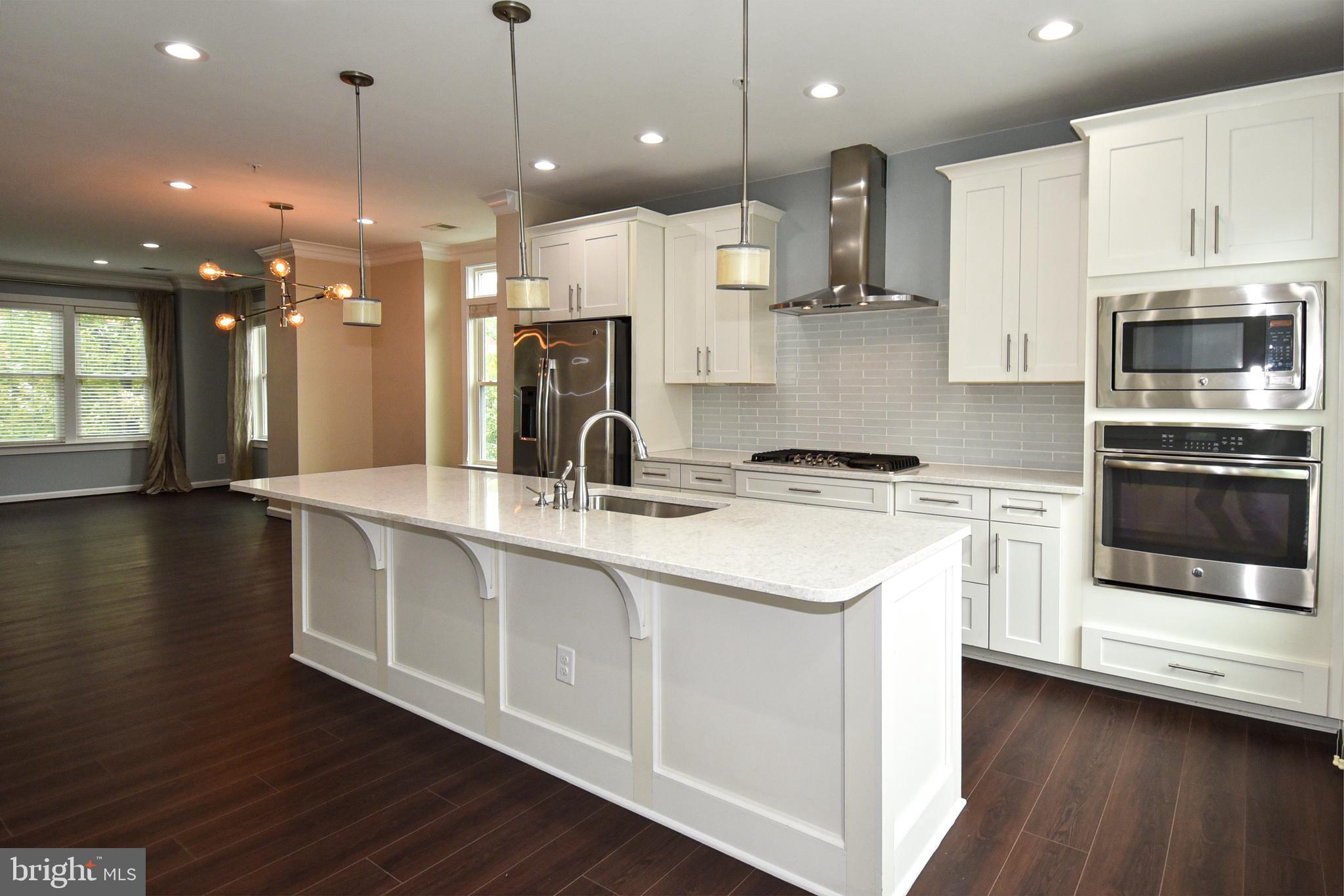 a kitchen with kitchen island a sink stainless steel appliances and cabinets