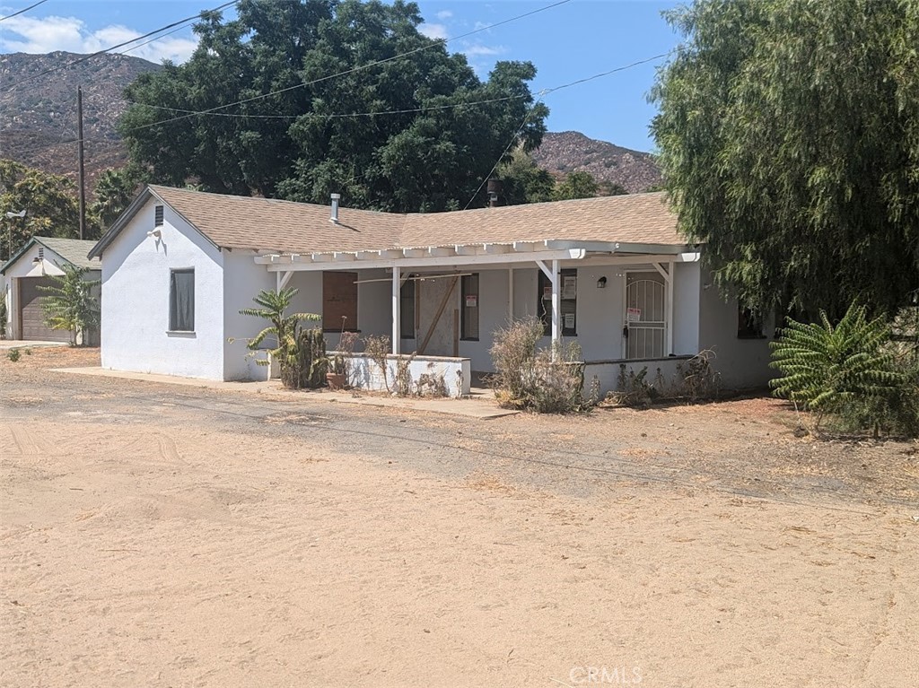 a front view of a house with a yard and potted plants