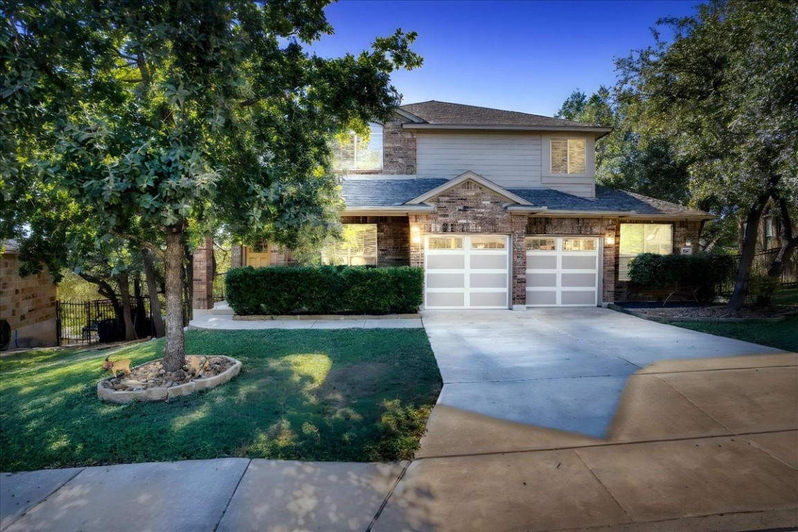 a front view of a house with a yard and a tree